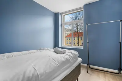 a blue room with a bed and a window at BRAND NEW! Bergen Beds Apartments I Cozy Corner in Bergen