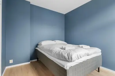 a bed in a room with blue walls at BRAND NEW! Bergen Beds Apartments I Cozy Corner in Bergen