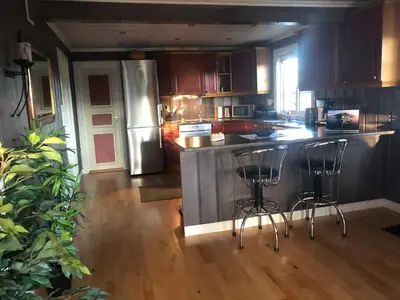 a kitchen with a counter and two bar stools at Skeitunet in Svingvoll