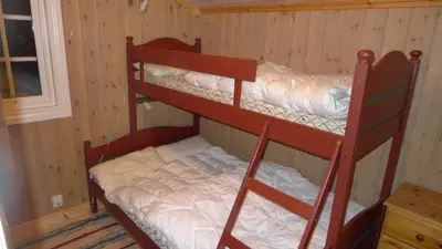 two bunk beds in a room with wooden walls at Skeitunet in Svingvoll
