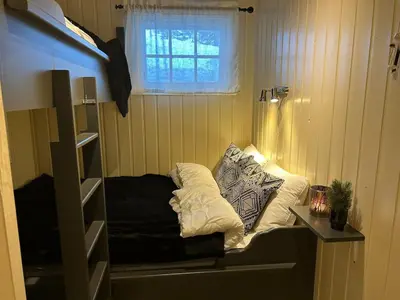 a bedroom with a bunk bed and a window at Gvelvåsen Panorama, Blefjell, family cabin with view and nature in Flesberg