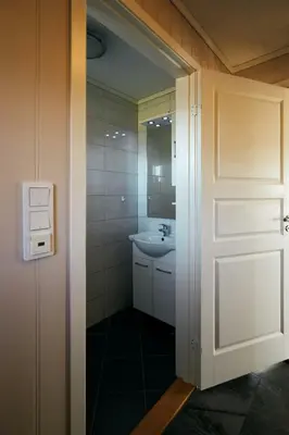 a bathroom with a white door and a sink at Home in Sylta