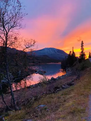 a sunset over a lake with a mountain in the background at 3 Bedroom Apartment with nice view by Gaustatoppen in Gaustablikk
