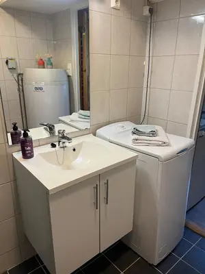 a white bathroom with a sink and a mirror at Leilighet i Lillehammer med gratis parkering in Lillehammer