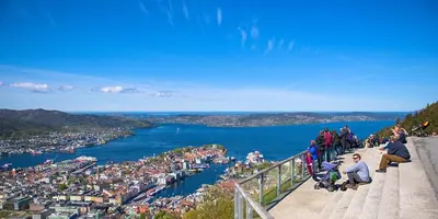 a group of people sitting on a ledge overlooking a body of water at Nice apartment in modern complex near Old Bergen in Bergen
