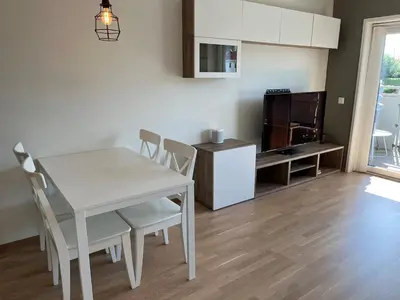 a kitchen and dining room with a white table and chairs at Nice apartment in modern complex near Old Bergen in Bergen