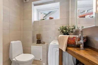 a bathroom with a toilet and a sink and a mirror at Cozy apartment in City Center in Bergen