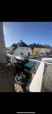 a balcony with a grill on a table on a deck at Cozy apartment in City Center in Bergen