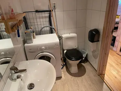 a bathroom with a washing machine and a sink at Syndinstøga in Ryfoss