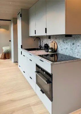 a kitchen with white cabinets and black counter tops at Flåm Retreat in Aurland