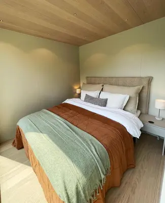 a bedroom with a large bed with a wooden ceiling at Flåm Retreat in Aurland