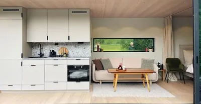 a kitchen with white cabinets and a table in a room at Flåm Retreat in Aurland