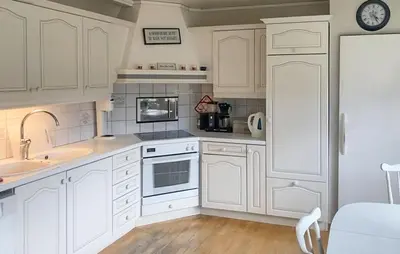 a white kitchen with white cabinets and a sink at 4 Bedroom Nice Home In Flornes in Flornes