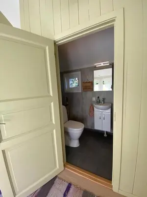 a bathroom with a toilet and a sink at Lite hus i hagen in Malvik