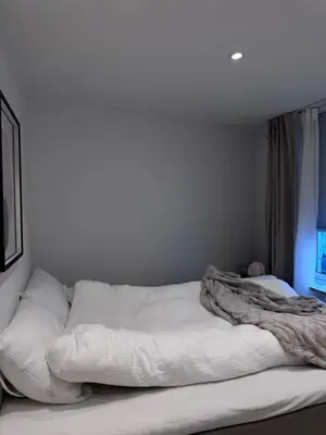 a white bed sitting in a room with a window at Sental apartment in Sandviken in Bergen