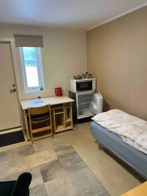 a bedroom with a bed and a desk and a microwave at Small apartment in Meldal in Syrstad