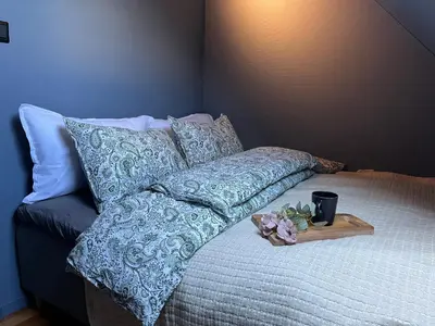 a bed with pillows and a tray of flowers on it at The Jugend Loft in Ålesund