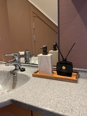 a bathroom sink with a soap dispenser and a mirror at The Jugend Loft in Ålesund