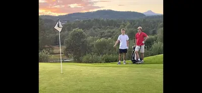 two people are standing on a golf course at The Jugend Loft in Ålesund