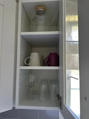a cupboard filled with dishes and a wine glass at Maria apartment with Sauna Otta in Otta