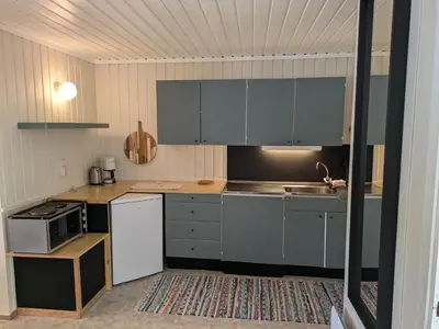 a kitchen with gray cabinets and a stove top oven at Myrland Apartments in Hovet
