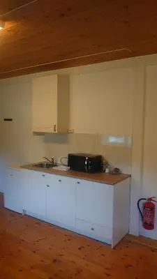 a kitchen with white cabinets and a counter top at Studio apartment 48m2 in Hølera