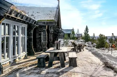 a stone building with benches in front of a building at Large and cozy family cabin with sauna in Trysil