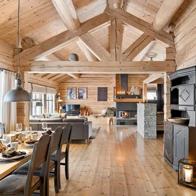 a kitchen and living room with wooden ceilings at Large and cozy family cabin with sauna in Trysil