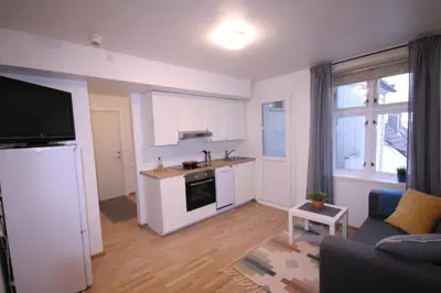 a kitchen and living room with a refrigerator and a couch at Super cozy 3-bedroom in picturesque neigborhood in Bergen