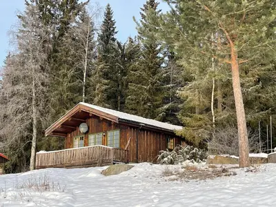 a log cabin in the snow with trees at Hagali by Norgesbooking - cabin by the lake Næra, close to Sjusjøen in Ringsaker