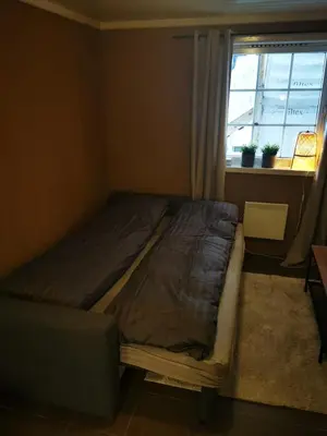 a bed sitting in a room with a window at Cozy apartment close to many experiences in Segalstad
