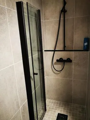 a shower with a glass door in a bathroom at Cozy apartment close to many experiences in Segalstad