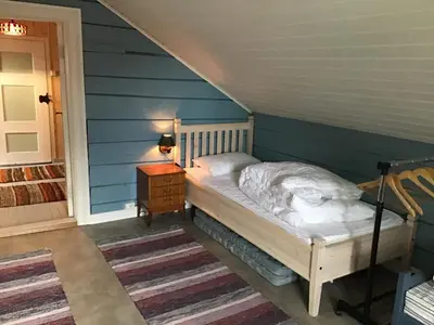 a bed in a room with a blue wall at Gamlemgarden by Norgesbooking - house by the sea in Longva