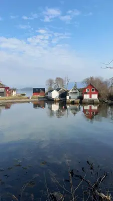a group of houses sitting next to a body of water at Large villa with boathouse in Lunde