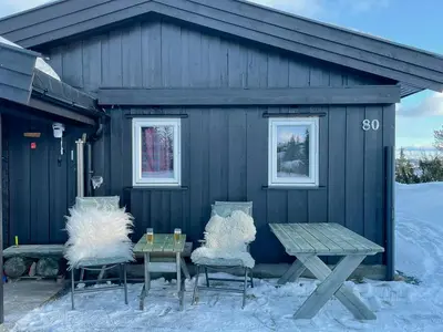 two chairs and a table in front of a building at Family Cabin With Views In Valdres in Reinli
