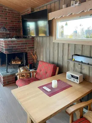 a living room with a table and a fireplace at Family Cabin With Views In Valdres in Reinli