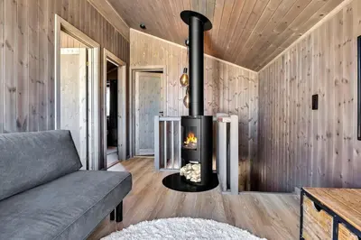 a fireplace in the living room of a house at New, cozy cottage on Norefjell with stunning views in Noresund