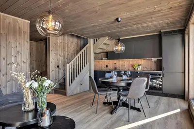 a dining room with a table and chairs at New, cozy cottage on Norefjell with stunning views in Noresund