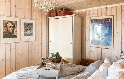 a bedroom with a bed and a cabinet and a chandelier at Beautiful Home In Sjusjøen With Wifi in Sjusjøen