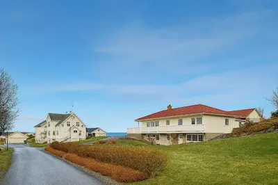a house on a hill next to a road at Leilighet sentralt i Bud in Bud