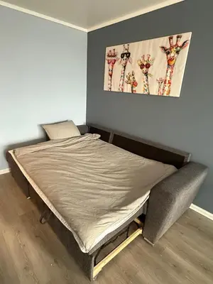 a bed in a room with a picture on the wall at Apartment by the center of Ålesund in Ålesund