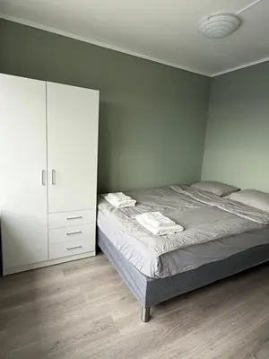 a bedroom with a bed and a white cabinet at Apartment by the center of Ålesund in Ålesund