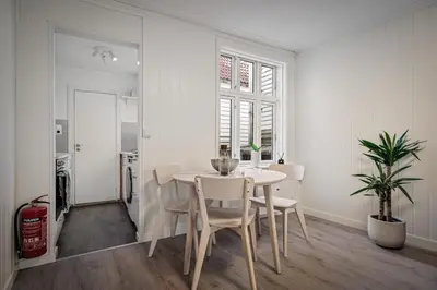 a white dining room with a table and chairs at Bergen style Apt I Cozy street I Easy check in in Bergen