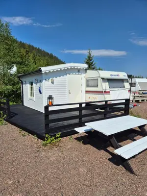 a small white trailer with a picnic table and a bench at Trysil Caravan Cycle in-out in Trysil