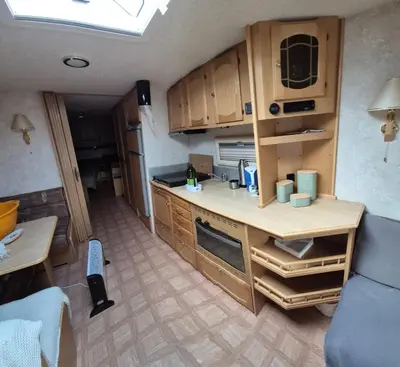 a small kitchen with wooden cabinets in a room at Trysil Caravan Cycle in-out in Trysil