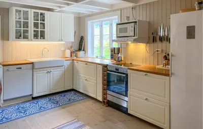 a kitchen with white cabinets and a sink and a refrigerator at Stunning Home In Runde With Wifi in Runde