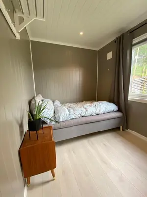 a bedroom with a bed in a room with a window at Cabin for rent in scenic Stryn in Stryn