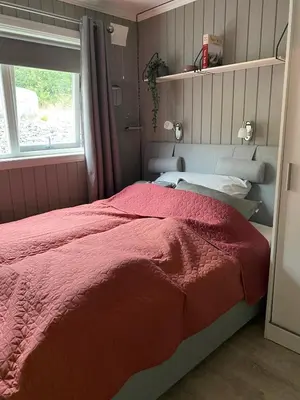 a bedroom with a bed with a red comforter at Cabin for rent in scenic Stryn in Stryn