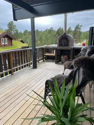 a wooden deck with a fireplace on a house at Cabin for rent in scenic Stryn in Stryn