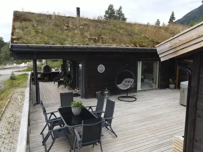 a patio with a table and chairs on a wooden deck at Cabin for rent in scenic Stryn in Stryn